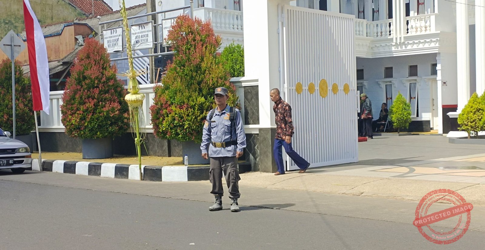 Anggota Linmas Desa Rancah, Kartono, saat mengamankan jalan 
